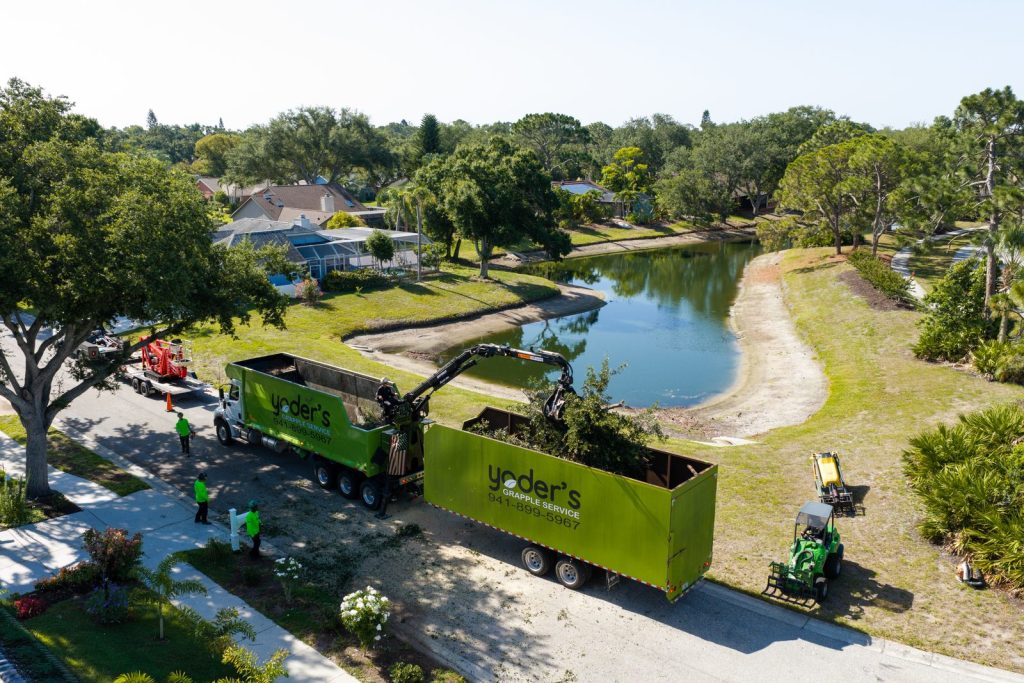 Aerial view of storm debris being loaded by a grapple truck in Southwest Florida