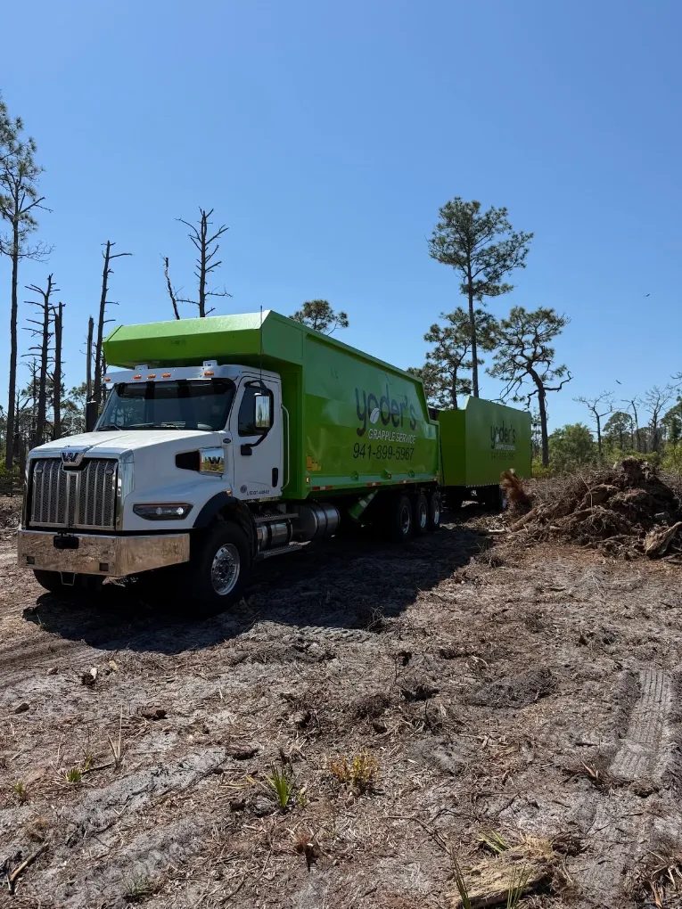 Grapple truck parked on a freshly cleared lot after a land clearing haul-off