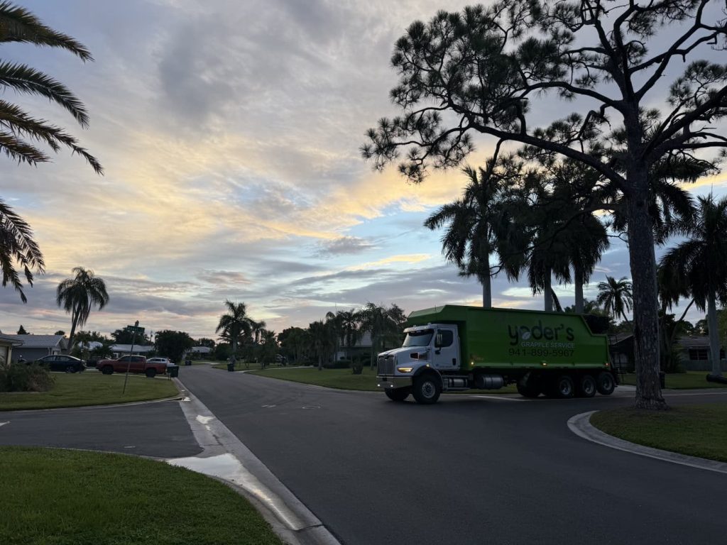 Yoder's Grapple Service truck heading to a green waste pickup on a residential street in Sarasota, FL